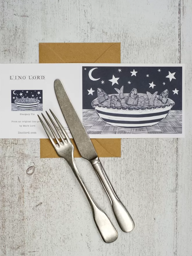 Greeting Card with an image of a Fish Pie in a stripey dish, with the fish gazing up at the stars in the sky, taken from an original lino print
