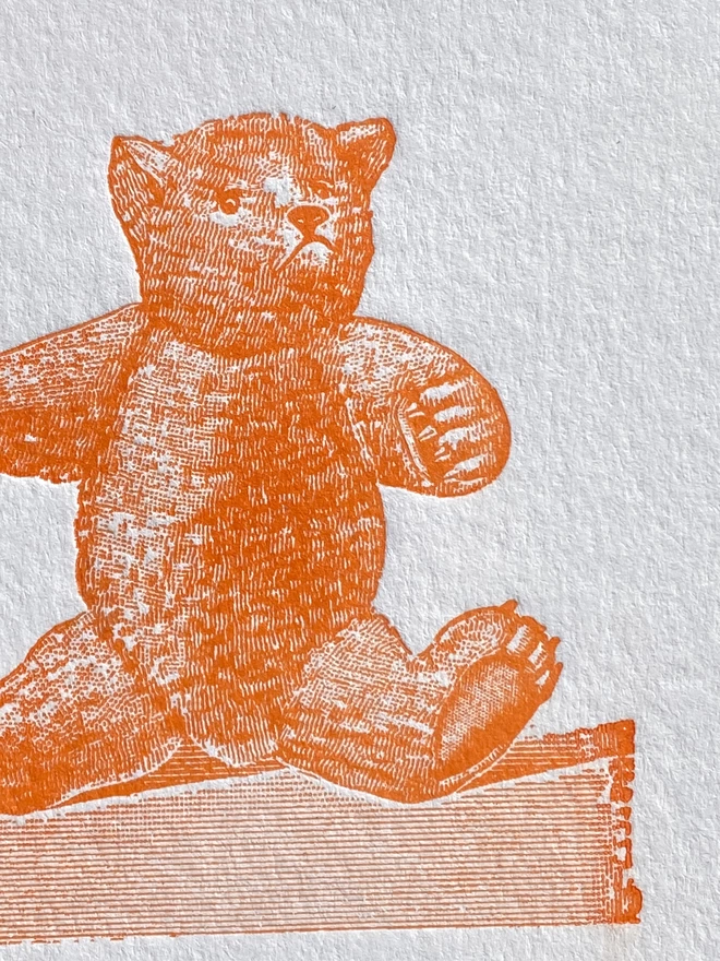 Close up of a white card with an orange illustration of a teddy bear