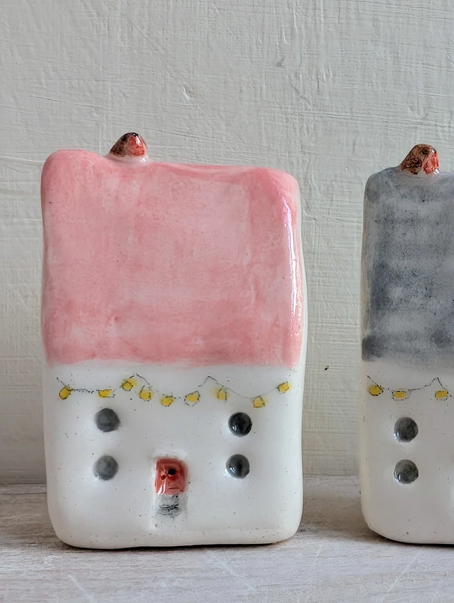 tiny pink ceramic house with tiny robin and fairy lights