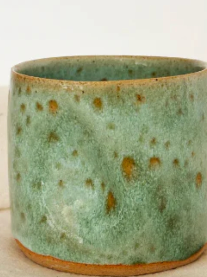 Pinch Mug. Close up of a Green Mini Pinch Mug against a cream background.