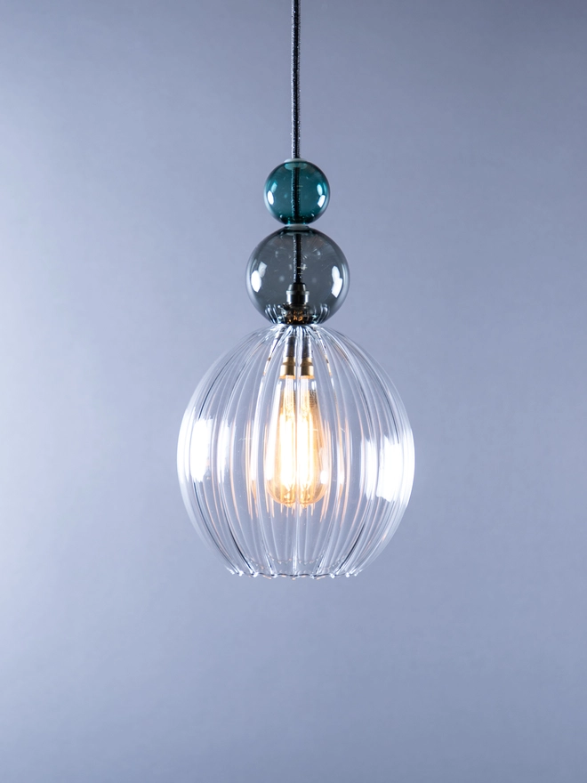 small clear ribbed Signature Wanda with a large smoke bauble and a small teal bauble