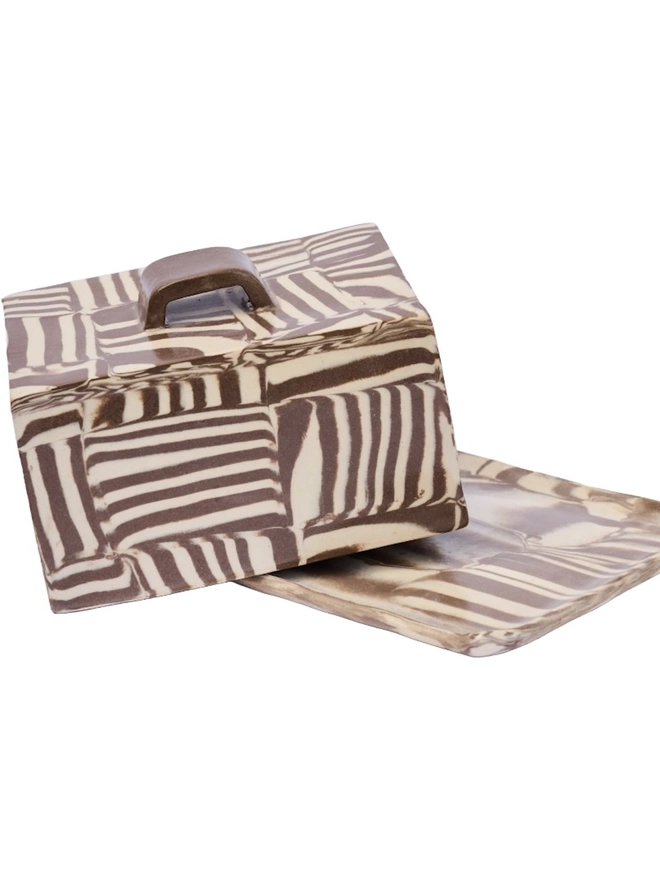 Striped Butter Dish, a colourful striped butter dish sitting on a white surface against a plain backdrop. 