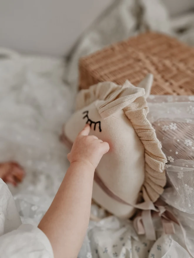 Horse Baby Rattle Toy, a child with a horse baby rattle toy in a bedroom surrounded by other bedroom accessories. 