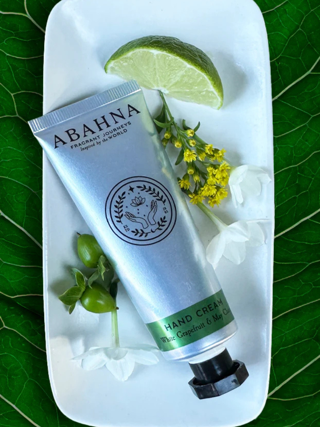 white grapefruit and may chang botanical hand cream. a silver tube containing hand lotion.