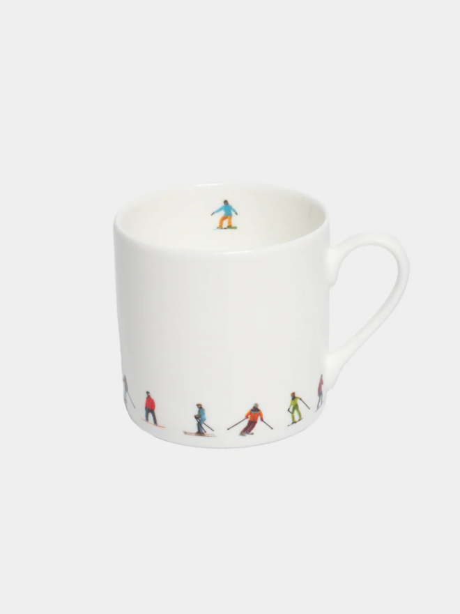 Ski Chain Espresso Cup. The white cup is patterned on its lower portion with a simple, multicoloured chain of skiers. It is set against a plain, white background.