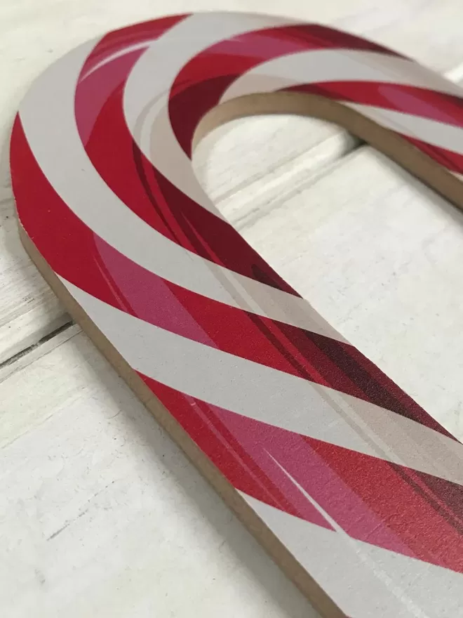 Close up of a candy cane in red by The Prop Factory