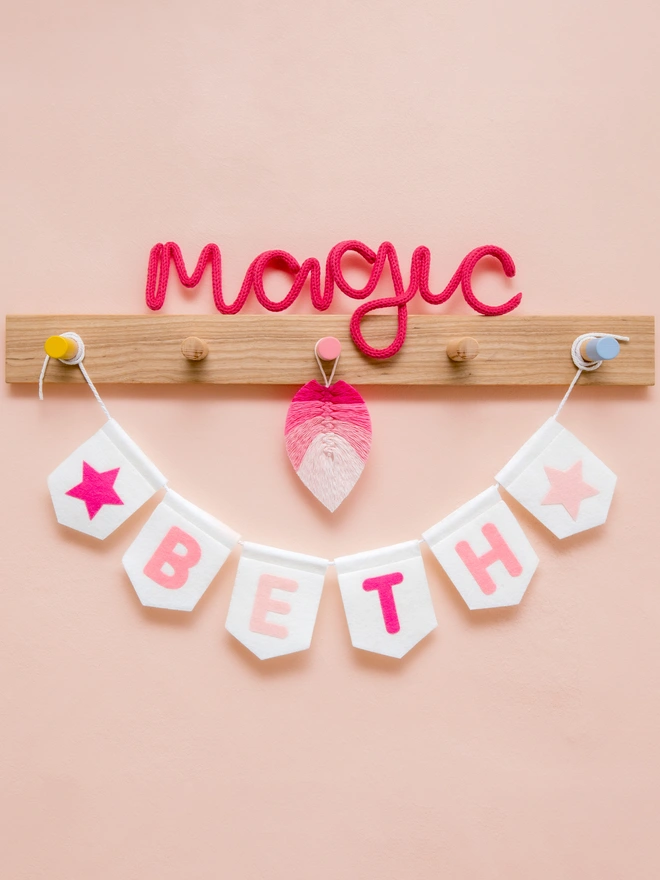 Personalised children's bunting. The text is a mix of pinks on white felt flags. 