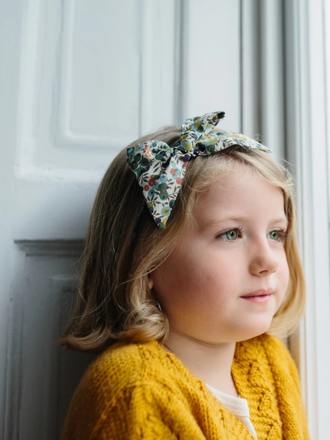 Little girl wearing a liberty alice band handmade by Runaround Retro