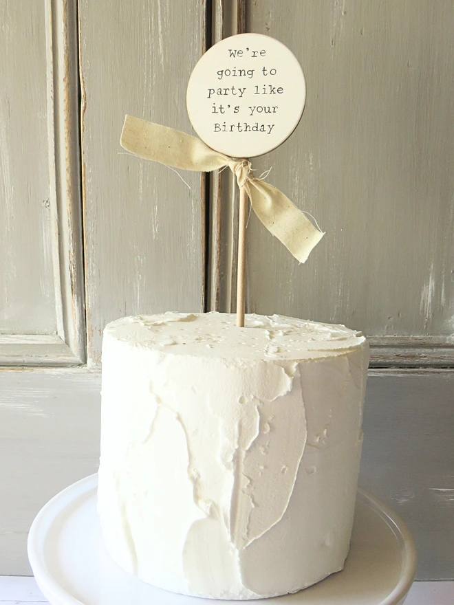 wooden circle shaped cake topper with hand painted message and custom ribbon