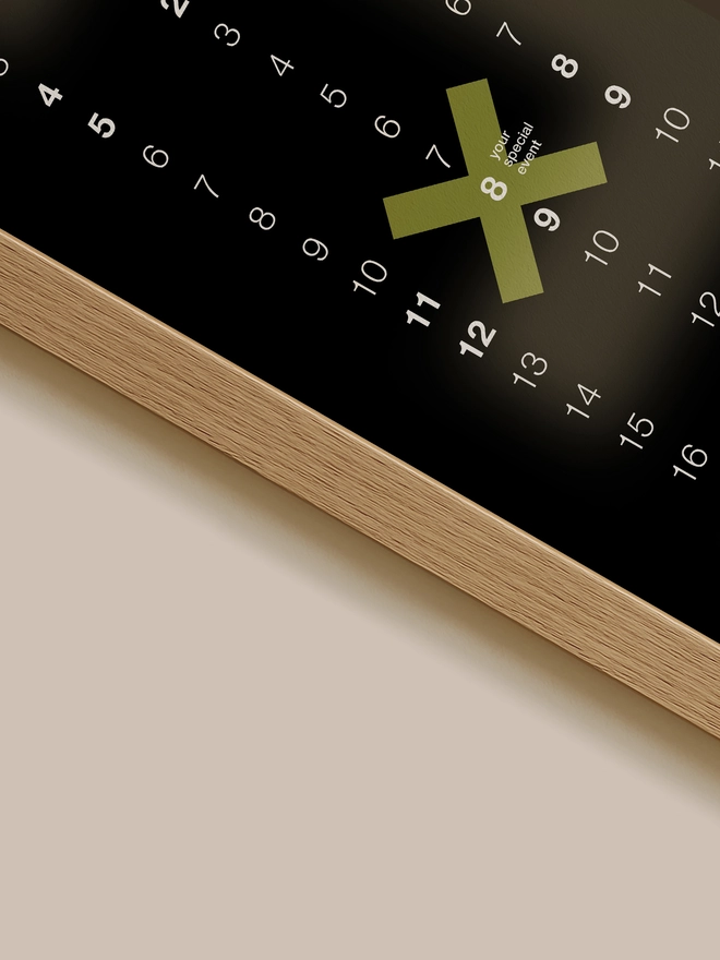 Closeup of a black Minx Personalised Date Poster on clay wall