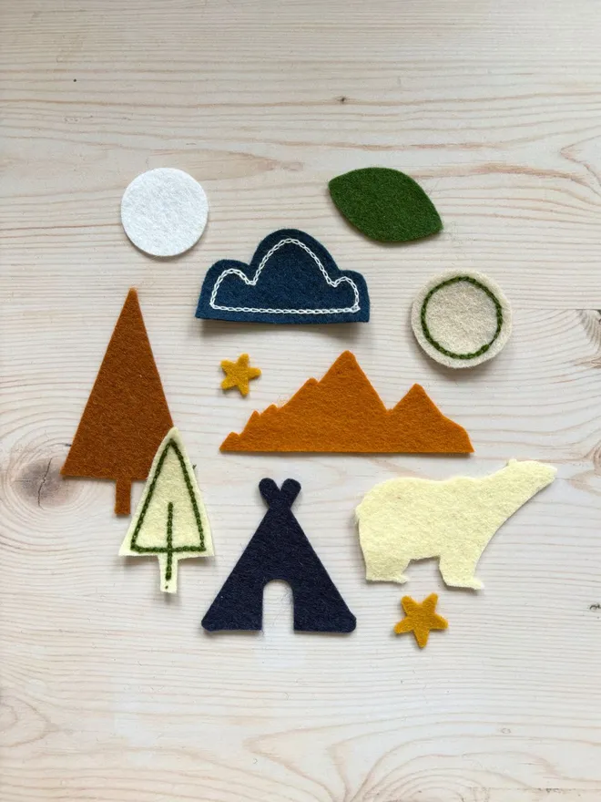 Felt shapes and scraps laid out with an instruction card on a wooden backround