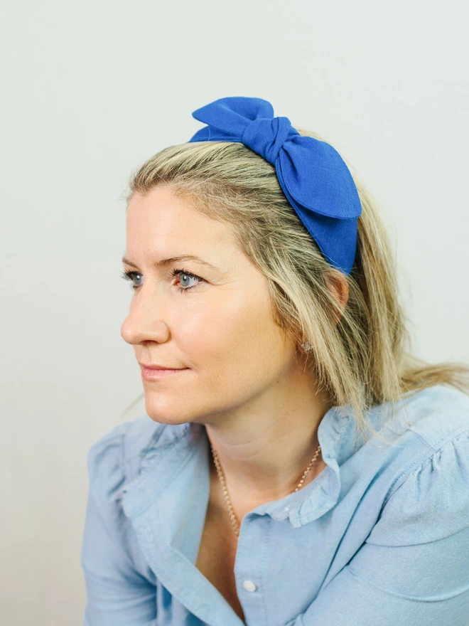 woman wearing side bow linen hairband in bright cobalt blue