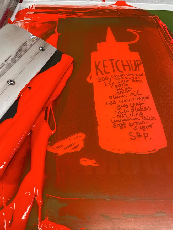 The screen used for the ketchup print, still with wet ink and squeegee in shot. 