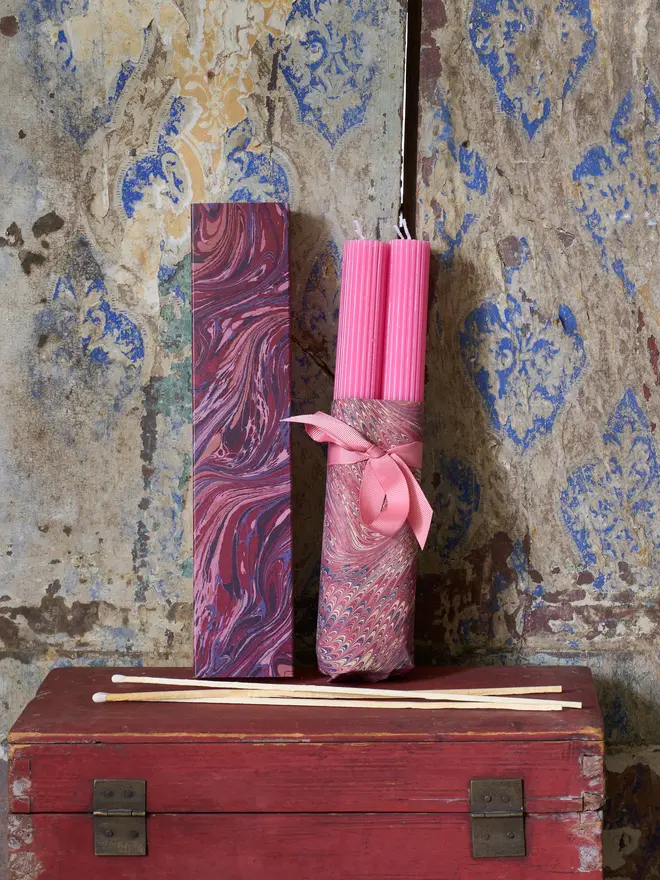 Scalloped fuchsia Candles with a box of long purple marbled matchbox