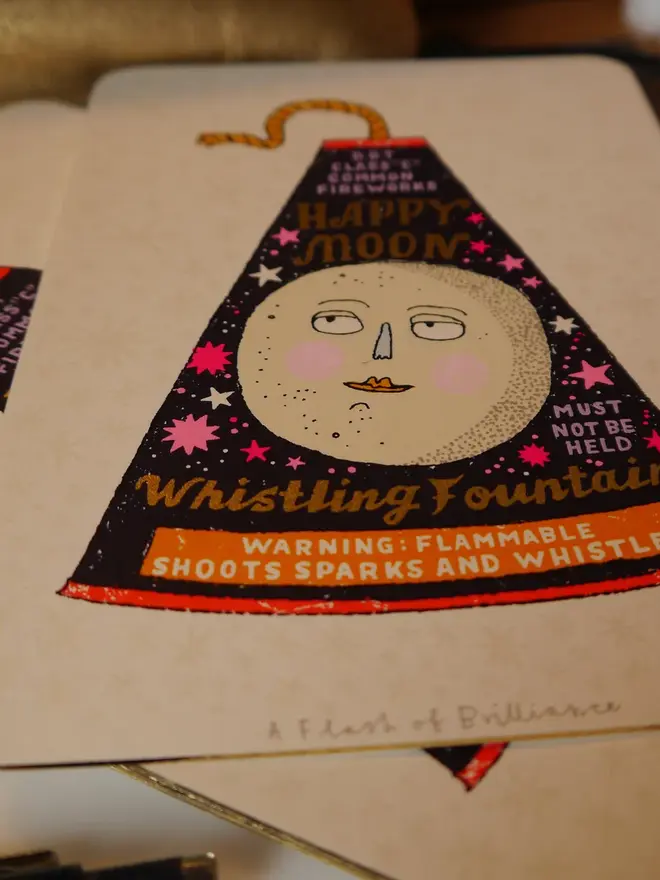 A Flash Of Brilliance Moon Firework Screenprint, a colourful firework design in the centre of a white screenprint. 