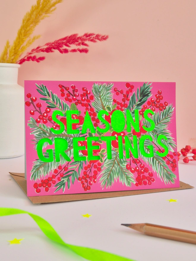 Cranberry design Christmas Card with Seasons greetings in paper cut text and a neon green backing paper 