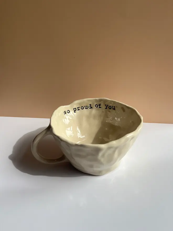 'So Proud Of You' Favourite Mug, positioned on table. 