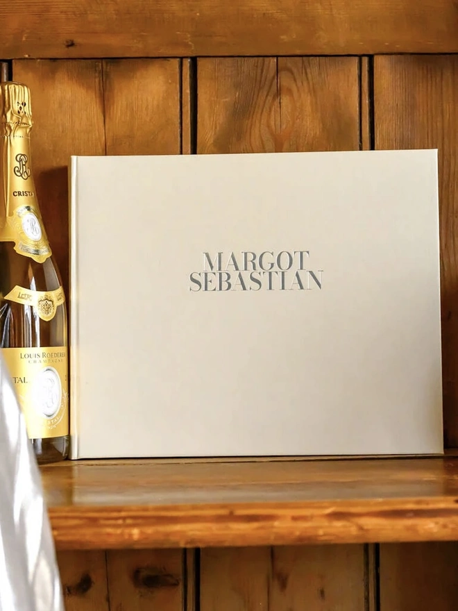 Personalised Large Wedding Guest Book With Two Names on a wooden table. 