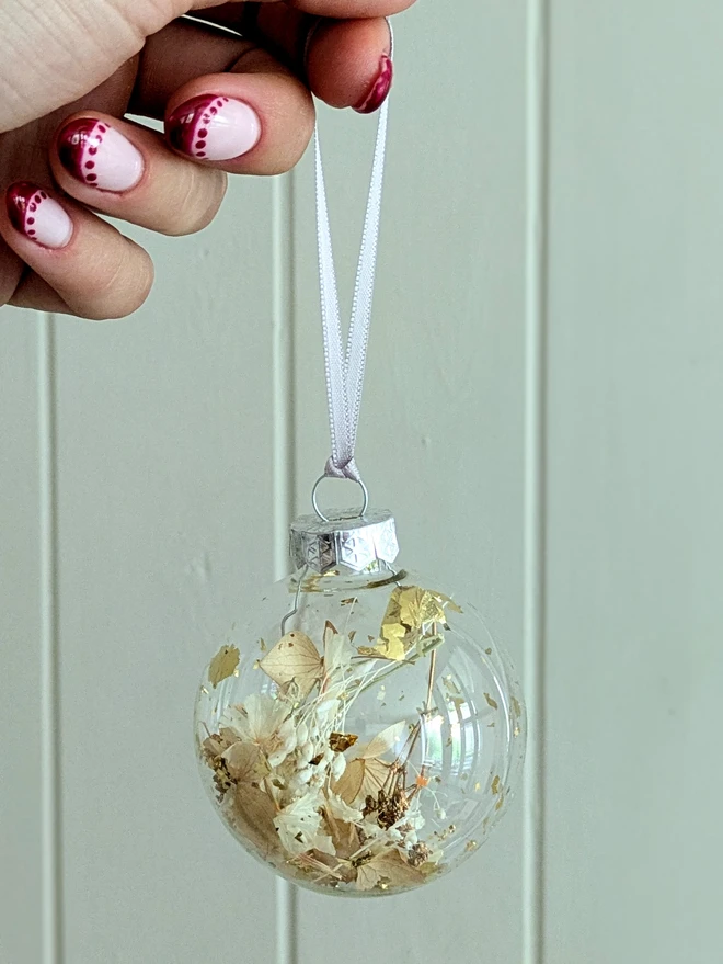 white flower petals with gold leaf in glass bauble