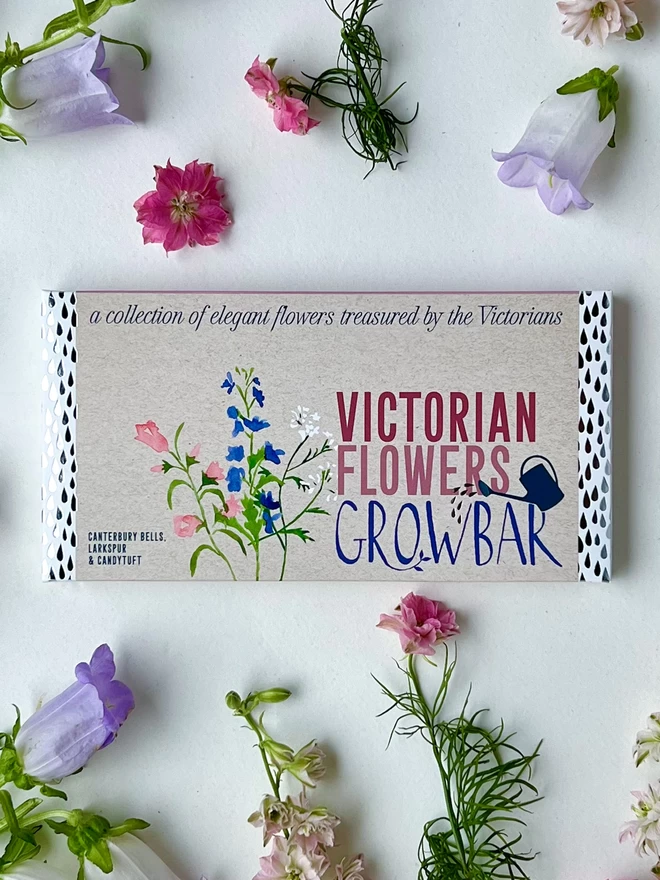 The Victorian Flowers Growbar surrounded by elegrant purple and pink flowers. 