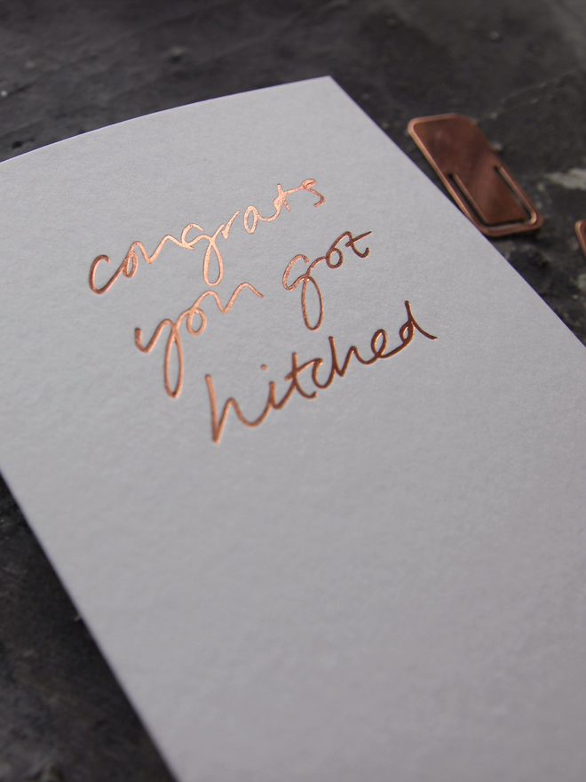 hand foiled card with a handwritten phrase that says Congrats You Got Hitched