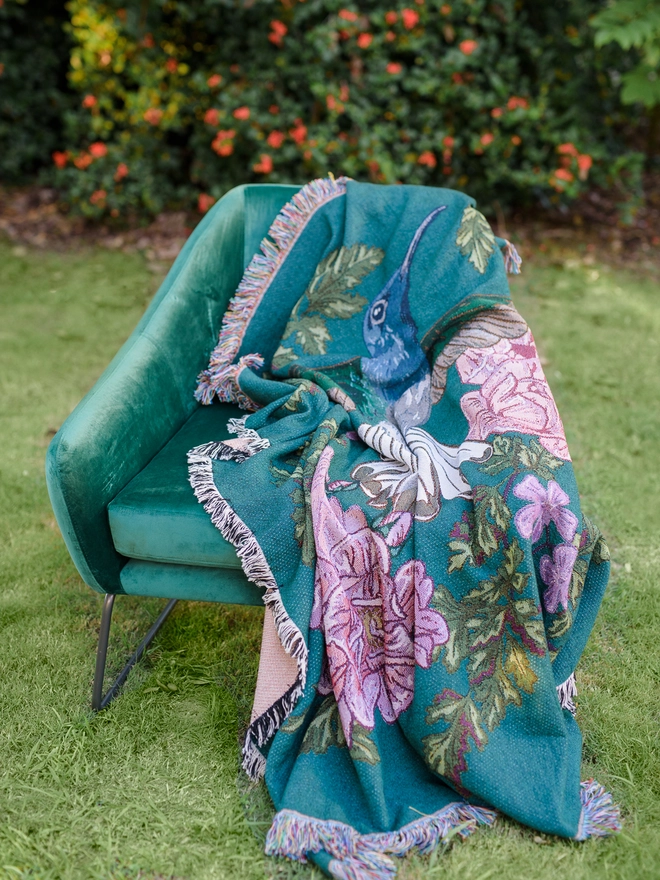 Joy Hummingbird Woven Blanket on chair