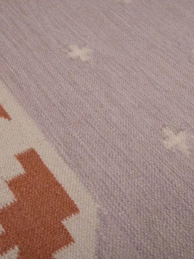 Manali Flatweave Rug, a colourful rug sitting on a plain surface. 