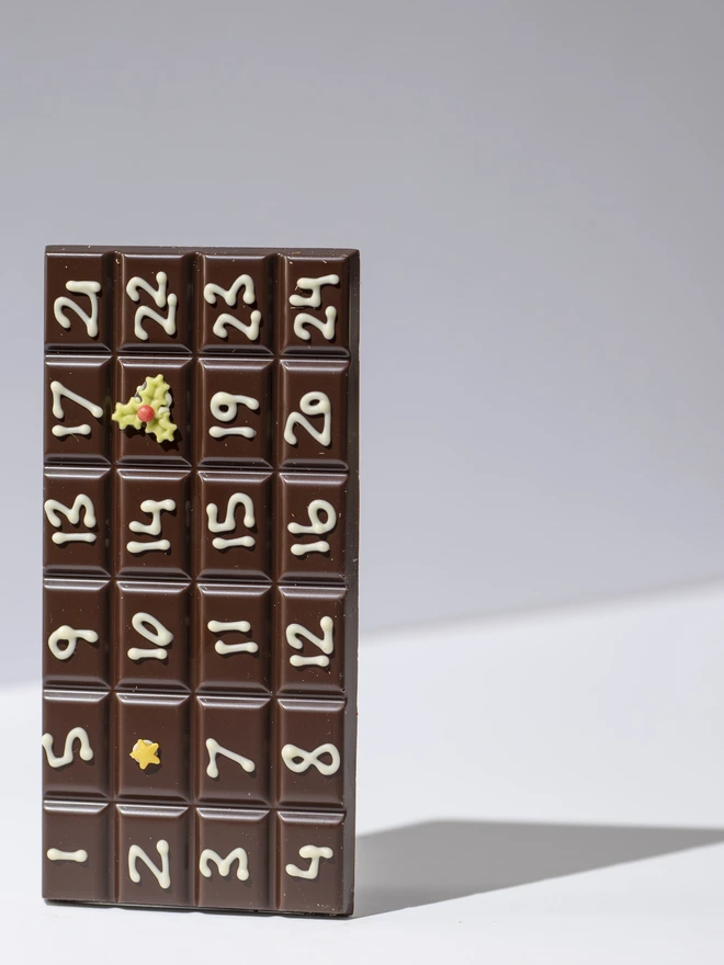 A solid bar of chocolate hand piped with December dates from the 1st to the 24th
