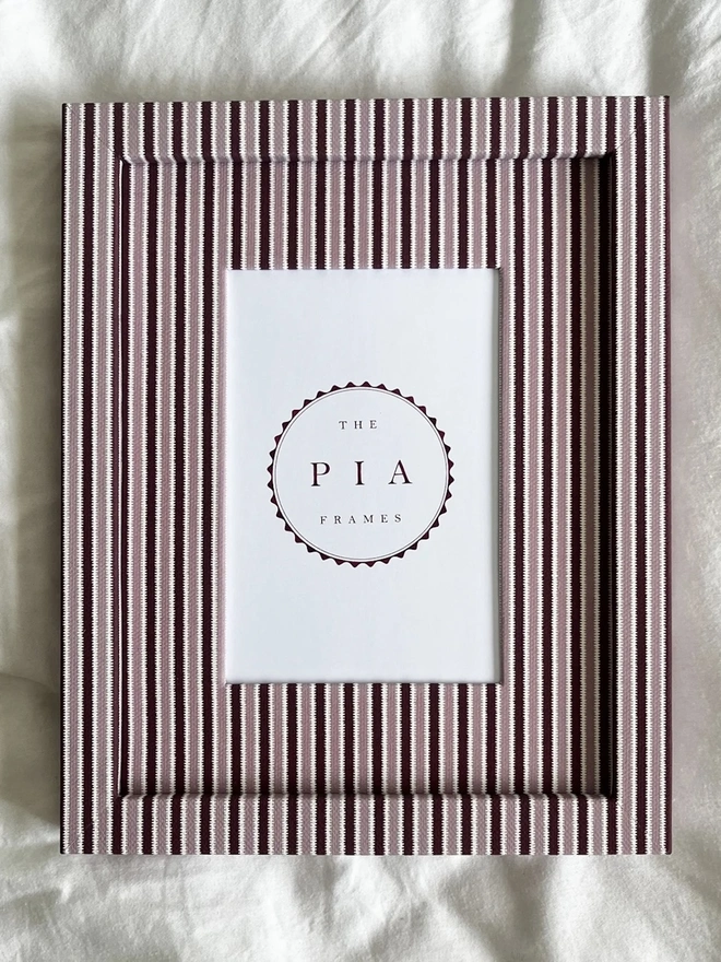 Blush & Burgundy Zigzag Frame, a colourful striped frame sitting on a plain white surface. 