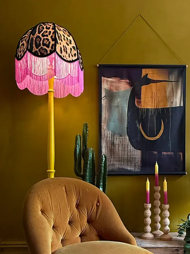 Vintage Fringed Lampshade in Leopardess With Pink Fringe, in a room. 