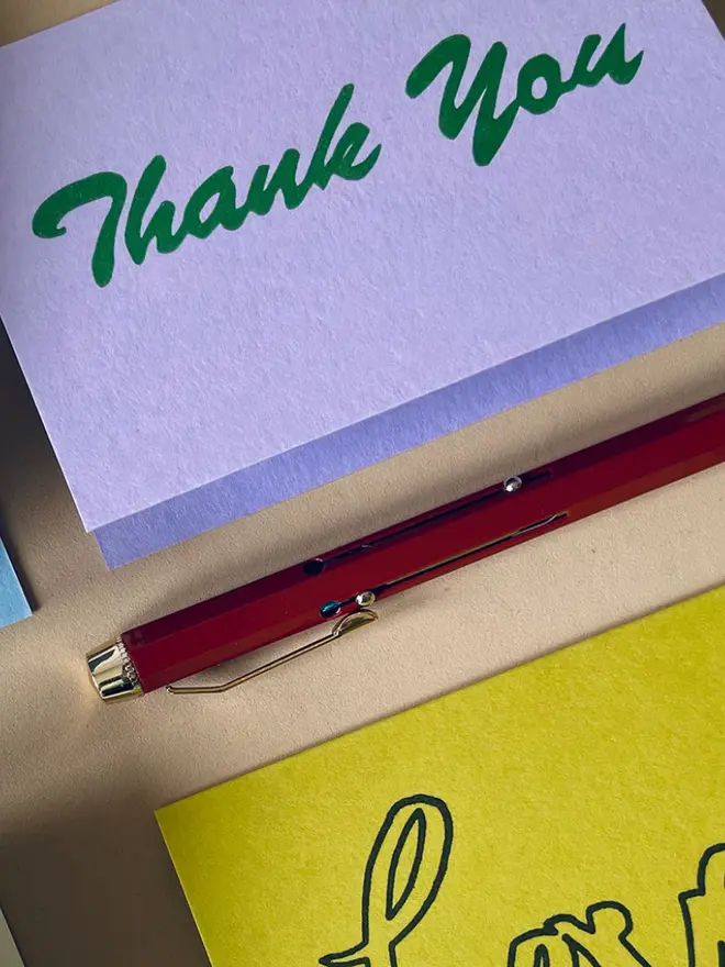 'Thank You' Hand Printed Card in green writing on a purple background. 