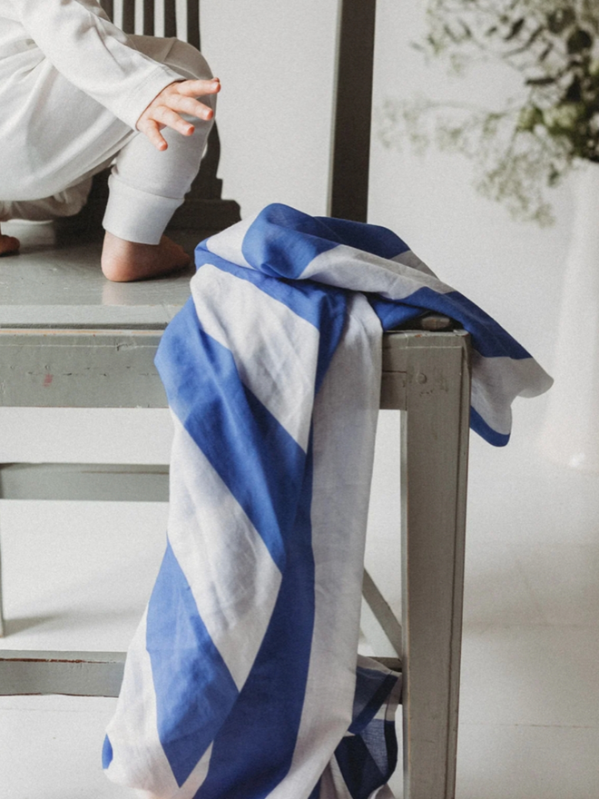 Blue Stripe Muslin. A bue striped muslin on a chair with a baby.