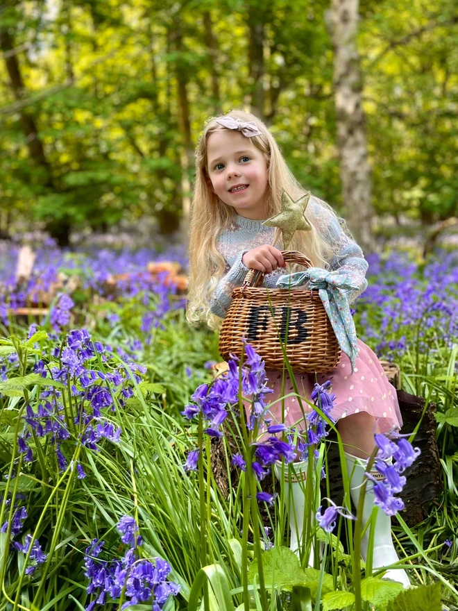 child in bluebells with personalised swing basket