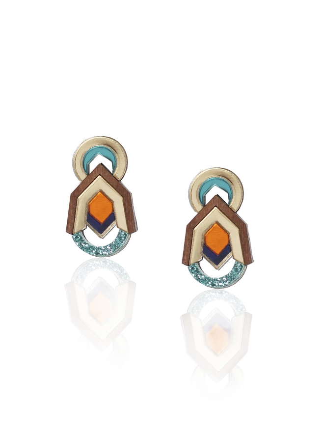 Elegant gold and teal acrylic earrings featuring a diamond-shaped center, adorned with small and larger arcs. The earrings are made from acrylics with a centre piece made from walnut wood.