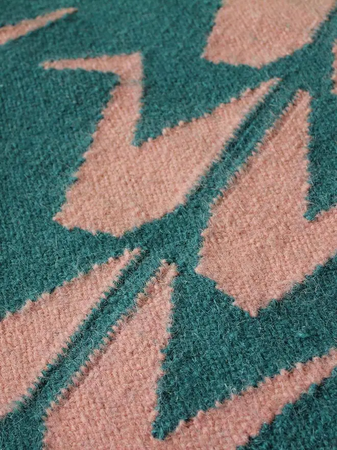 Crane Flatweave Rug, a colourful rug sitting on a plain surface. 