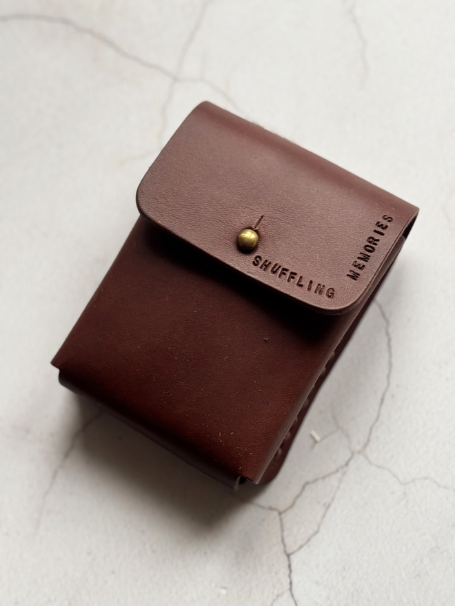 brown leather deck of cards holder stamped with 'shuffling memories'