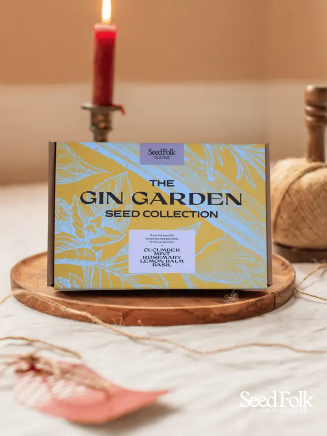 The Gin Garden Seed Collection Box. Beautiful box illustrated in blue and yellow botanical print, photographed on a wooden tray. 