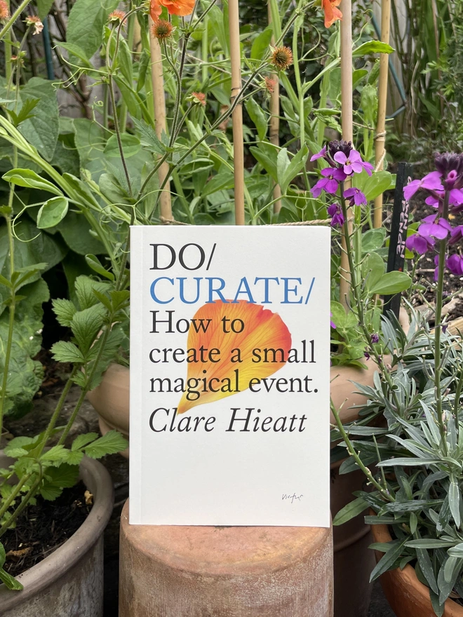 Book resting on terracotta pot in outdoor garden location