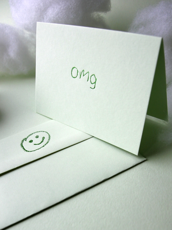 pistachio coloured card with omg short for 'oh my god' hand foiled in kids hand writing