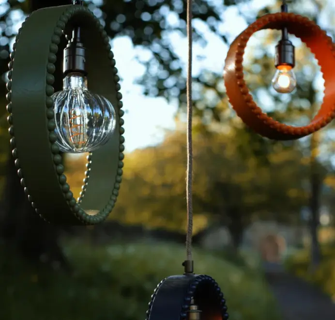 ring shaped pendant lamps with bobbin rims hanging from a tree