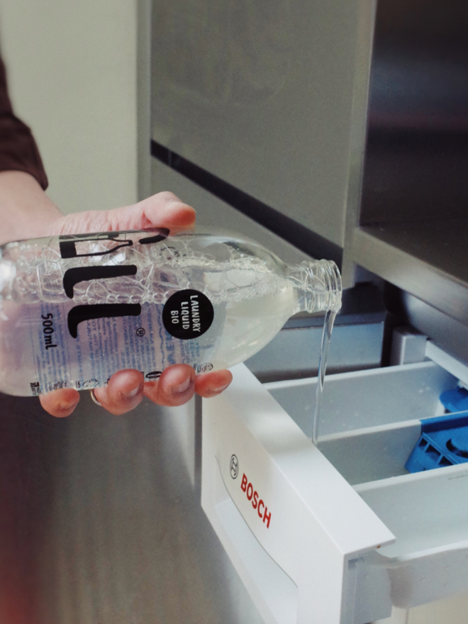 Laundry Liquid Bio. A bottle of laundry liquid being used.