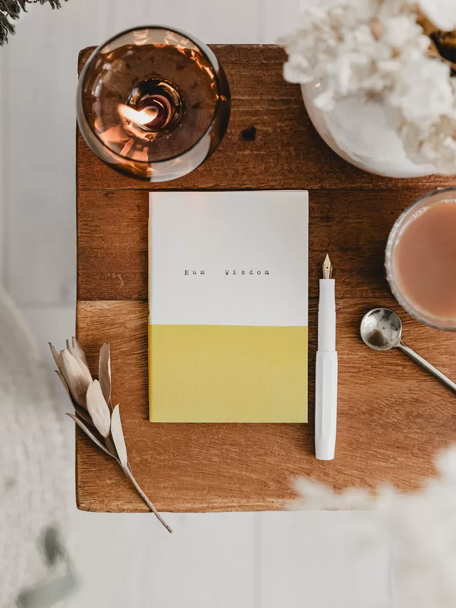 yellow and white pocket notebook with 'mum wisdom' typed on the cover