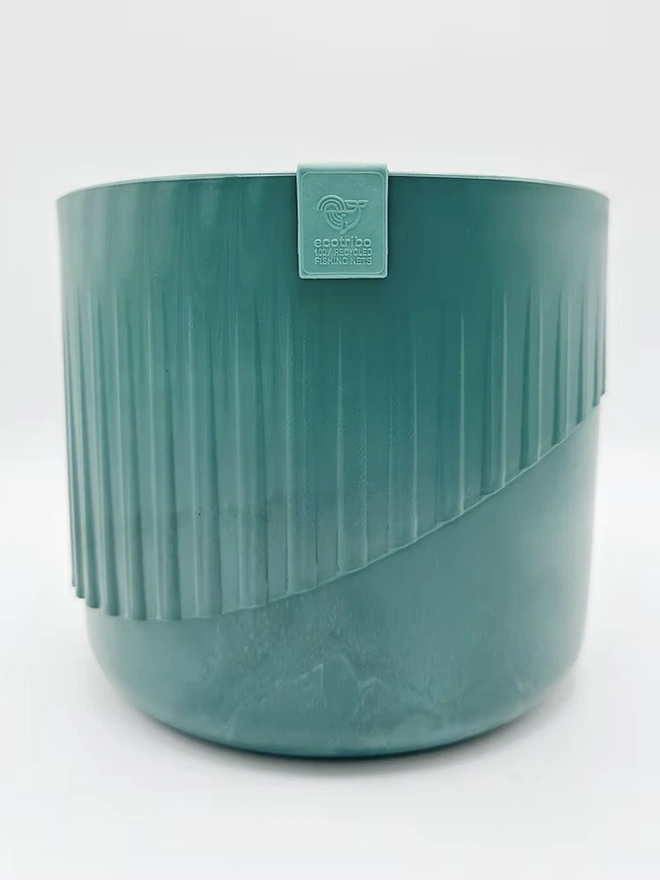 Ocean Plastic Plant Pot Medium, a recycled blue plant pot sitting on a plain surface against a white backdrop. 