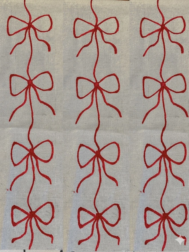 Hand Painted Bow Print Sustainable Linen Table Runner, a table runner with a red bow design. 
