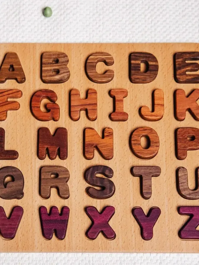 Wooden Uppercase Alphabet Puzzle Heirloom Toy, on a table. 