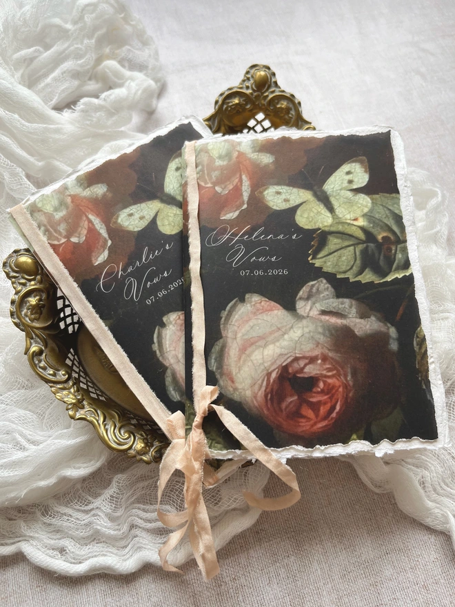 Butterfly and Roses vow booklet. A6 size tied with ribbon. Romantic floral booklet with the design printed on vellum and with 2 handmade paper inserts giving 8 sides on which to write your vows.