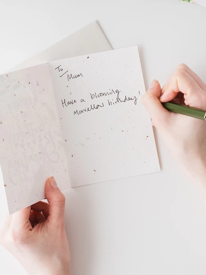 Writing a gift message inside Blooming Splendid Plantable Birthday Card