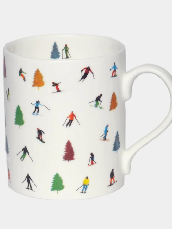 Tree Skiing Mug. A white mug patterned with illustrations of trees and skiers. The mug is set against a plain white background.