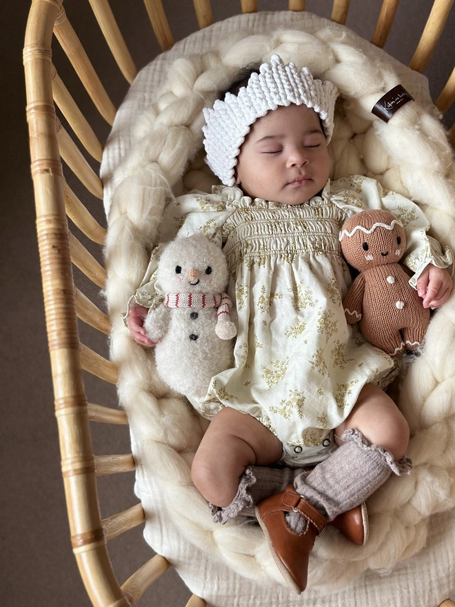 a baby girl in crochet crown moses basket