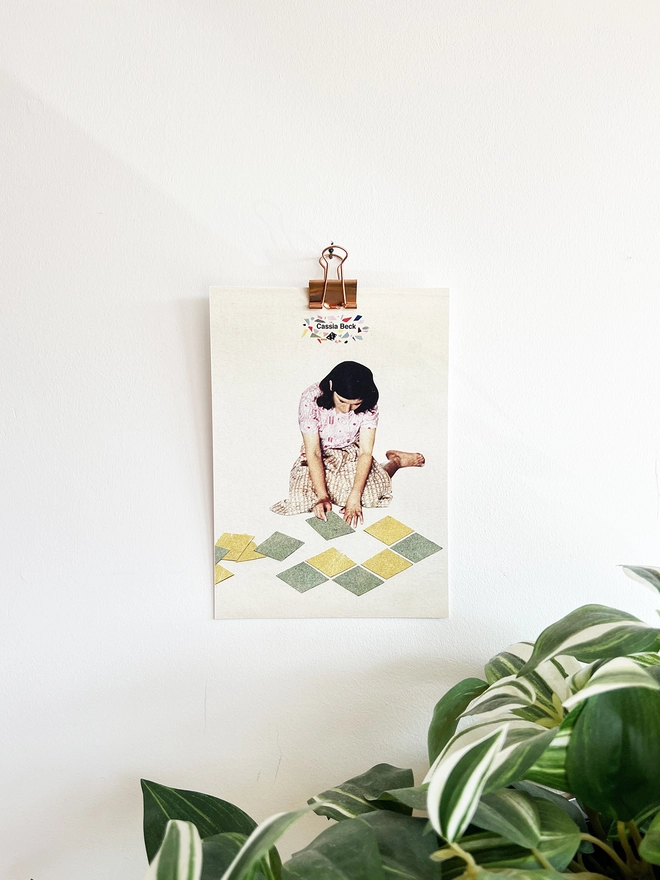 A page of a desk calendar hanging on the wall with a rose gold bulldog clip.